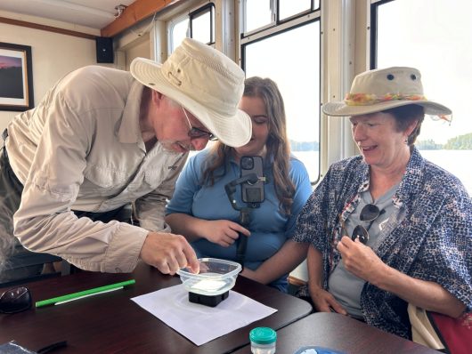 A photo of Norman Yan and Lenore Inniss examining animal plankton on board the Peerless on Lake Rosseau in September. Photo by Friends of the Muskoka Watershed.